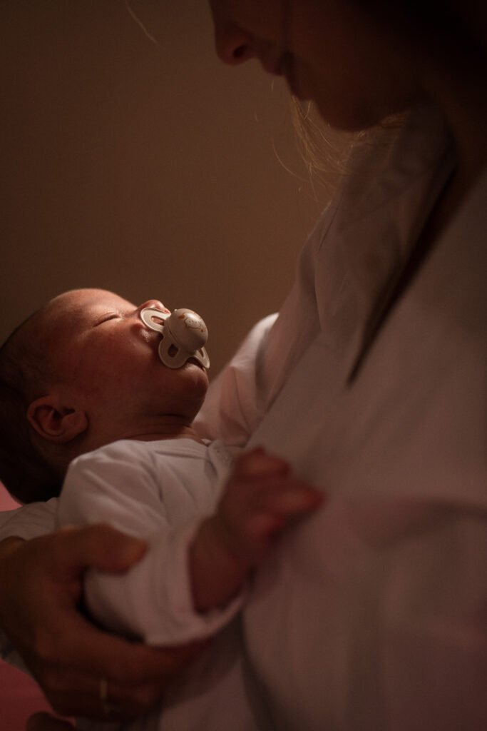 ouveau-né dans les bras de sa maman dans une lumière douce