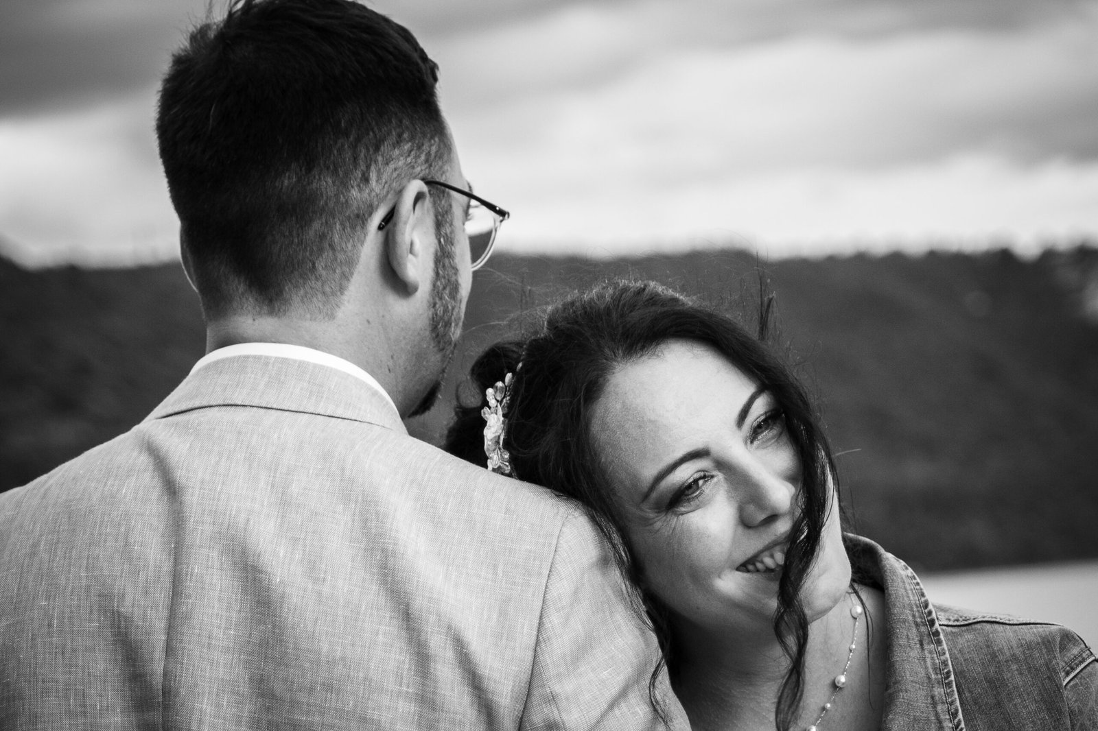 Couple de mariés enlacé dans un moment de tendresse en noir et blanc