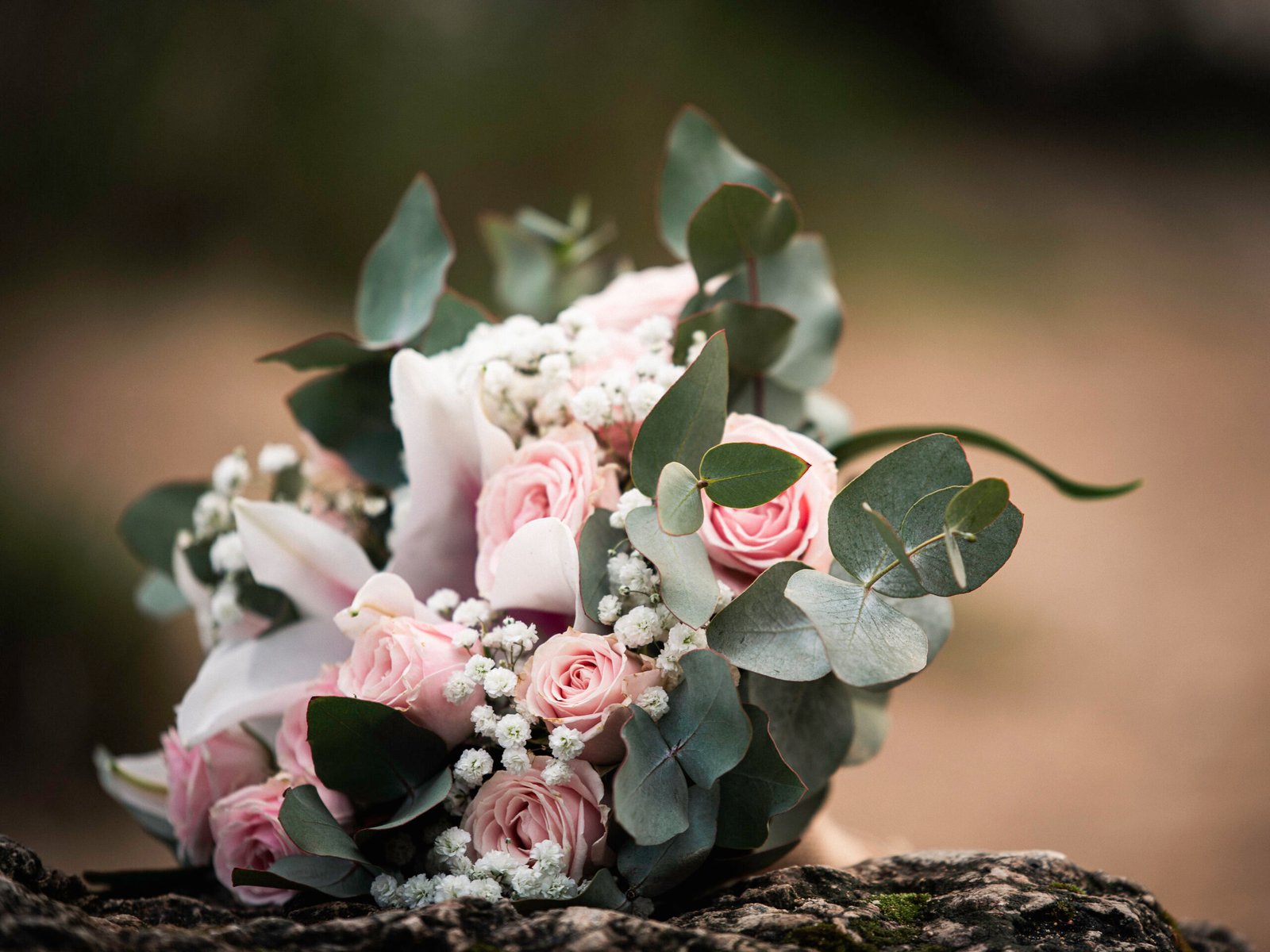 Bouquet de mariée aux fleurs roses posé pendant un mariage