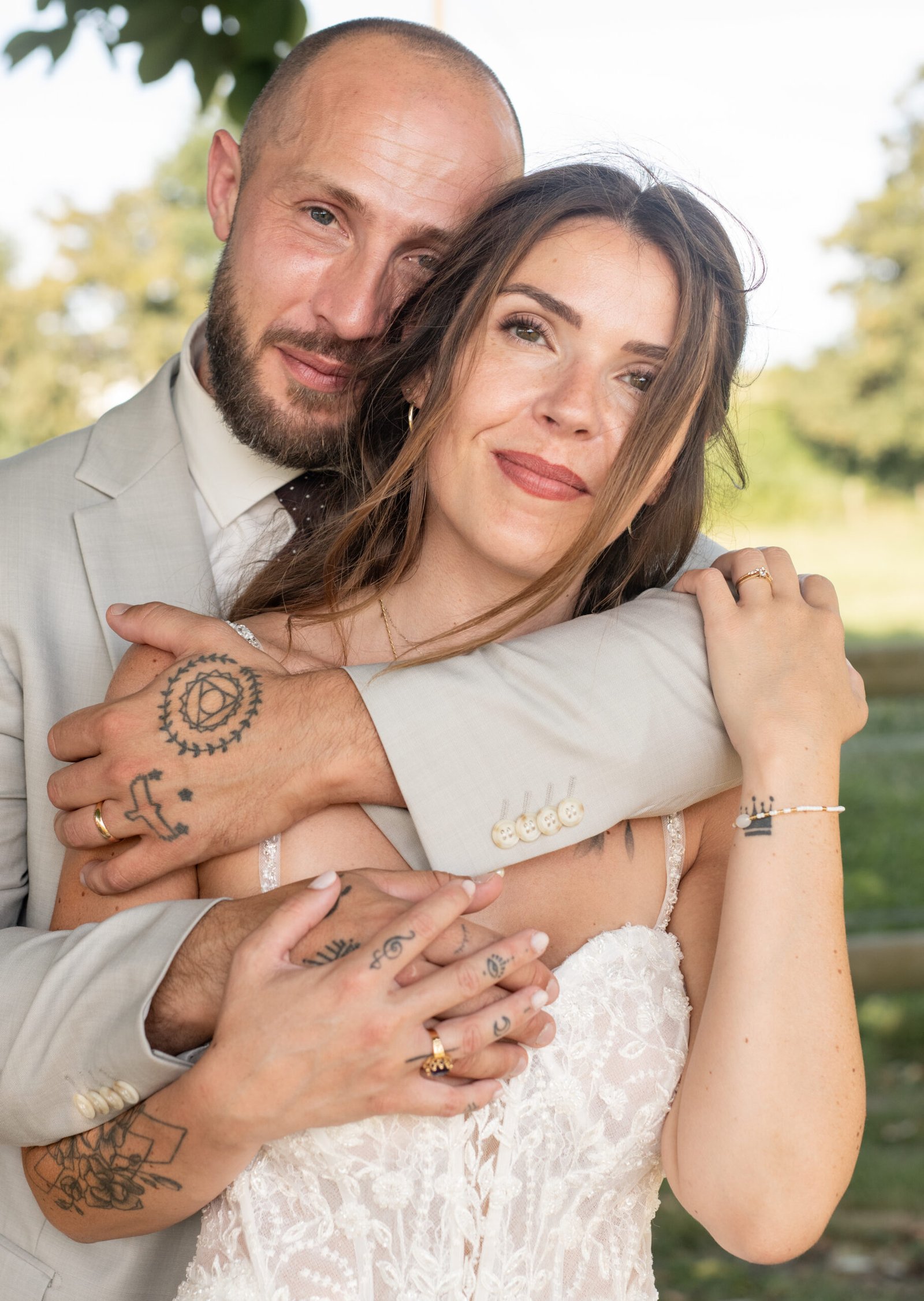 Portrait de mariés enlacés dans une lumière naturelle le jour de leur mariage